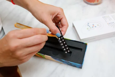 A beautifully organized tray featuring a LINGLONG JUHUO ear seed kit, tweezers, and a mirror in a self-care space.